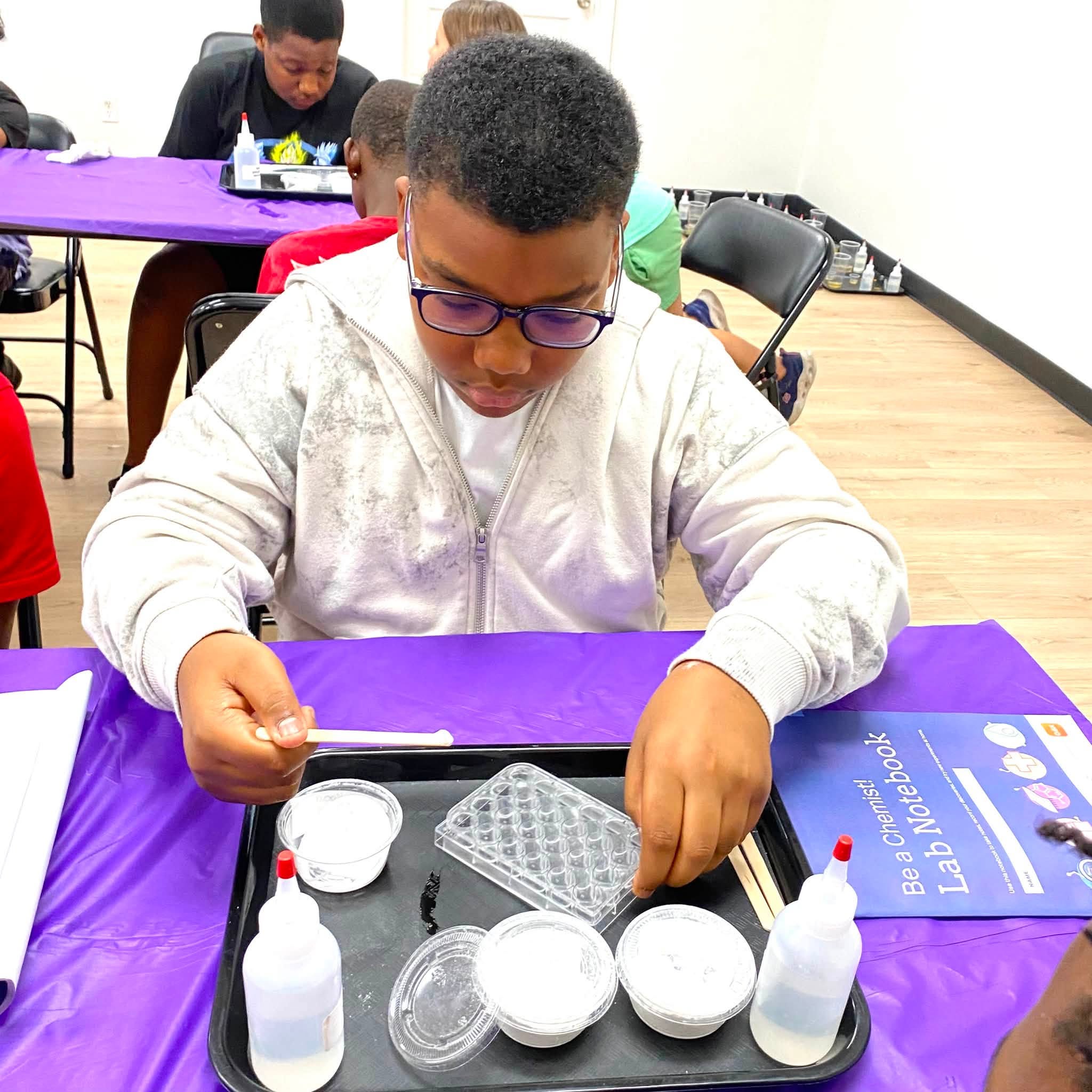 A boy doing a science experiment with powder and liquid.